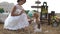 The side close-up portrait of the modern dressed bride playing with the dog at the background of the vintage composition