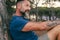 Side closeup portrait of adult man with beard smiling and enjoying relax time at the park. Happy and serene people with cheerful