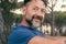 Side closeup portrait of adult man with beard smiling and enjoying relax time at the park. Happy and serene people with cheerful