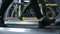 Side closeup view of a feet of a unrecognizable sportpeople in motion walking on treadmills in the gym warming up before