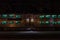 Side of commuter rail car at night with green tinted windows