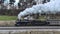 Side Drone View of a Steam Locomotive Approaching Traveling Thru Fields and Meadows