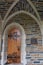 A side entryway to the Duke University Chapel, with an arched doorway, arched passageway and arched wood door