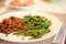 Side of fresh lightly cooked organic green beans on dinner plate