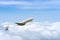 Side image commercial passenger aircraft or cargo transportation airplane flying through over white fluffy cloud with blue sky in