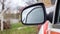 Side left black plastic rearview mirror on a white car. Exterior side-view mirror on the driver`s side, electrically adjustable