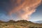 Side lit smokey clouds from the setting sun over the high desert hill tops