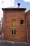 Side of an old brick building with a high loading door.