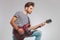 Side photo of artist in studio playing guitar