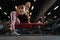 Side photo of young sports woman with ball in hand exercising on bench.