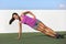 Side plank fitness woman training body core planking exercise. Workout at outdoor gym or home garden Asian girl