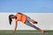 Side plank leg lift fitness woman training body core planking exercise. Workout at outdoor gym or home garden Asian girl