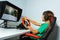 Side portrait of boy, hands on steering wheel play race game