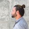 Side portrait of serious man with beard and hair bun