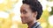 Side portrait of short haired african american girl ethnic woman standing alone outdoors in profile turns her head