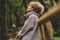 Side portrait of woman relaxing in the nature. Inner balance and mindfulness concept moments. Standing female people in the woods