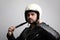 Side portrait of young bearded hipster biker man with white cafe-racer helmet. White background.
