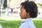 Side portrait of young children black ethic afro american diversity with green playground park in background. Dredd hair style