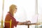 Side portrait young woman worker sitting in office while using laptop computer and typing by keyboard