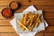 A side of potato fries with tomato sauce and chilly sauce.