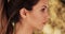 Side profile of beautiful Caucasian brunette model on bright bokeh background