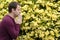 Side profile of man praying by yellow flowers.