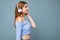 Side-profile photo of beautiful positive smiling young blonde woman wearing blue crop top isolated over blue background