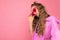 Side-profile photo shot of charming sorrowful young blonde curly woman isolated on pink background wall wearing casual