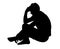 Side profile portrait silhouette of depressed teenage boy sitting on ground thinking