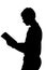 Side profile portrait silhouette of standing teenage boy reading