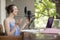 Side profile of a young woman recording a business podcast at home