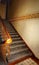 Side staircase in the building with wooden handrails and forged fencing.