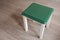 Side table with green top and white colored legs painted with chalk paint.