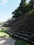 Side of three stony pyramids at ancient Mayan Palenque city at Mexico at landscape of jungle and grassy field - vertical