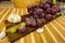 Side upper view of a red and yellow muscat colored grape, bottle of wine, garlic and a glass on a wooden board - still life