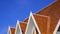 Side view of 3 gable roofs with small solar panel on top of Thai traditional pavilion against blue sky background