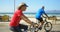 Side view of active senior Caucasian couple riding bicycle on a promenade at the beach 4k