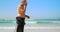 Side view of active senior Caucasian male surfer standing on the beach 4k