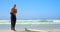 Side view of active senior Caucasian male surfer wearing wet suit on the beach 4k