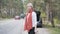 Side view of adult blond woman standing next to broken car with wrench and waiting for tow truck. Portrait of sad