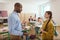 Side view of african american teacher gesturing and talking to schoolgirl