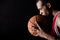 Side view of african sporty man holding basketball ball