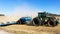 Side view agricultural tractor prepares duty soil affected by drought.