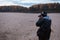 Side view of amateur photographer shooting the autumn scenery of the forest road. Landscape therapy