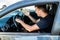 Side view of angry man in suit driving a car and beeps