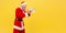 Side view of angry screaming elderly man with gray beard wearing santa claus costume holding