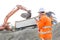 Side view of architect using walkie-talkie while working at construction site