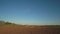 Side view as a pair of cyclists driving past a field