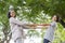 Side view of Asian mother and daughter holding hand and smile while standing in the park, Happy family concept