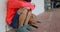 Side view of Asian schoolboy with head down sitting alone on the floor in corridor at school 4k